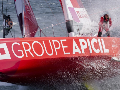 Silhouette lointaine d'un skippeur à bord d'un monocoque de course au large au large volant sur l'océan